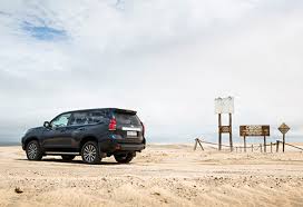 Land Cruiser aan zee op zandstrand